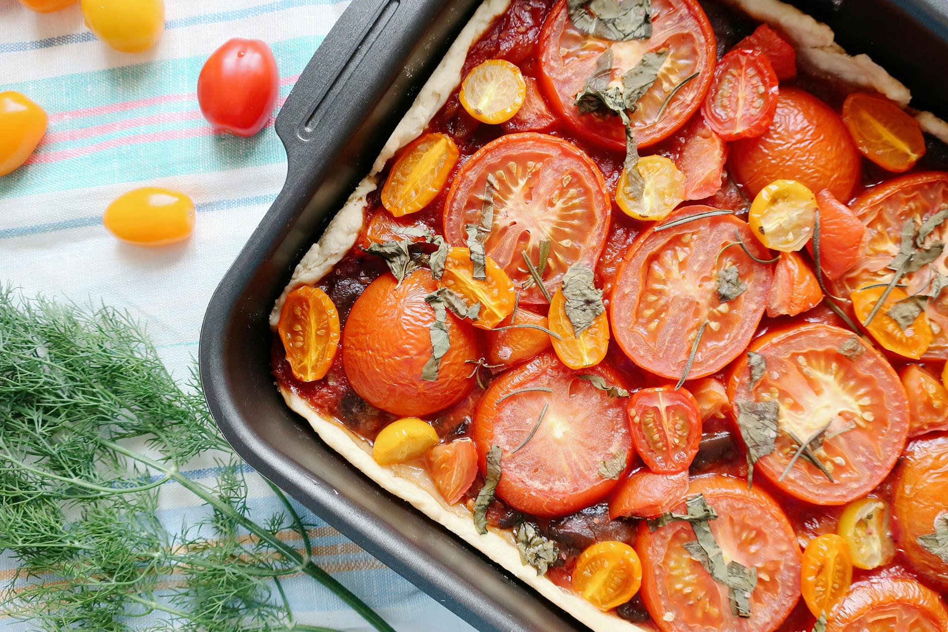 Rustic tomato galette with golden pastry edges and fresh basil